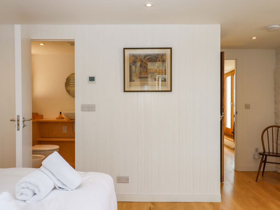 A bedroom with a bed and a towel at Dolphin Cottage in Brixham