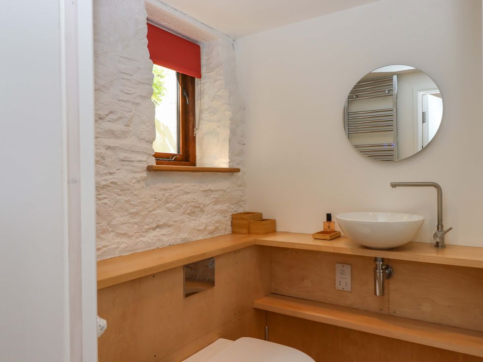 A bathroom with a sink and mirror at Dolphin Cottage in Brixham