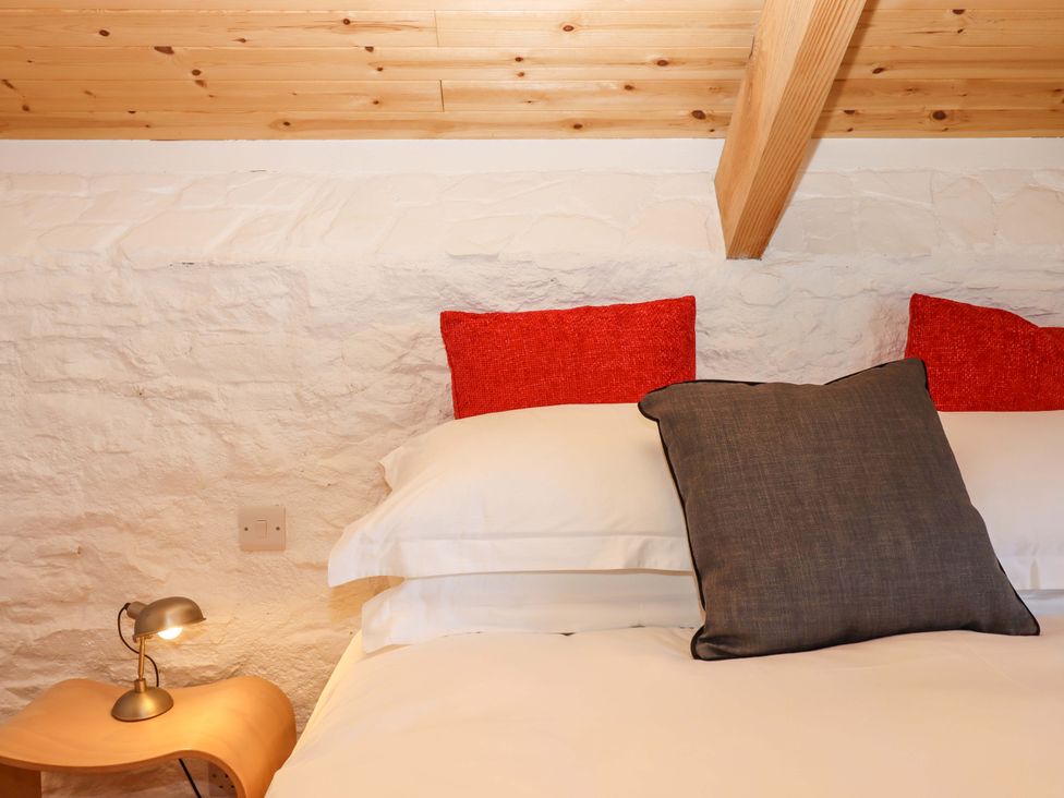 A bedroom with a bed and pillows at Dolphin Cottage in Brixham