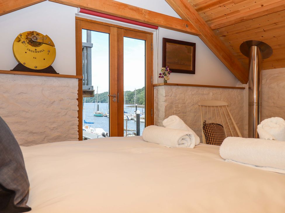 A bedroom with a view of water and boats at Dolphin Cottage in Brixham