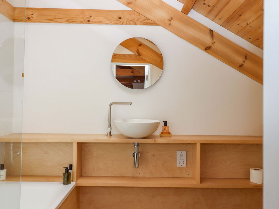 A bathroom with a sink and mirror at Dolphin Cottage in Brixham