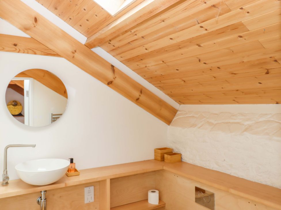A bathroom with a sink and mirror at Dolphin Cottage in Brixham