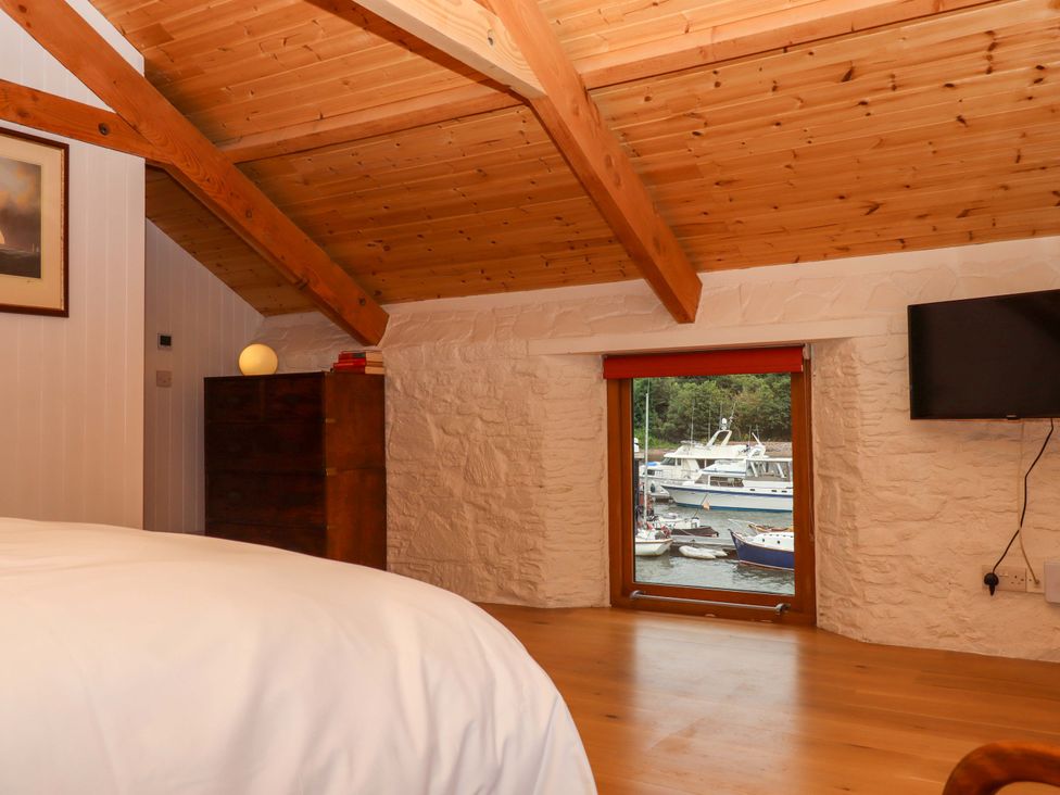 A bedroom with a window overlooking boats at Dolphin Cottage in Brixham