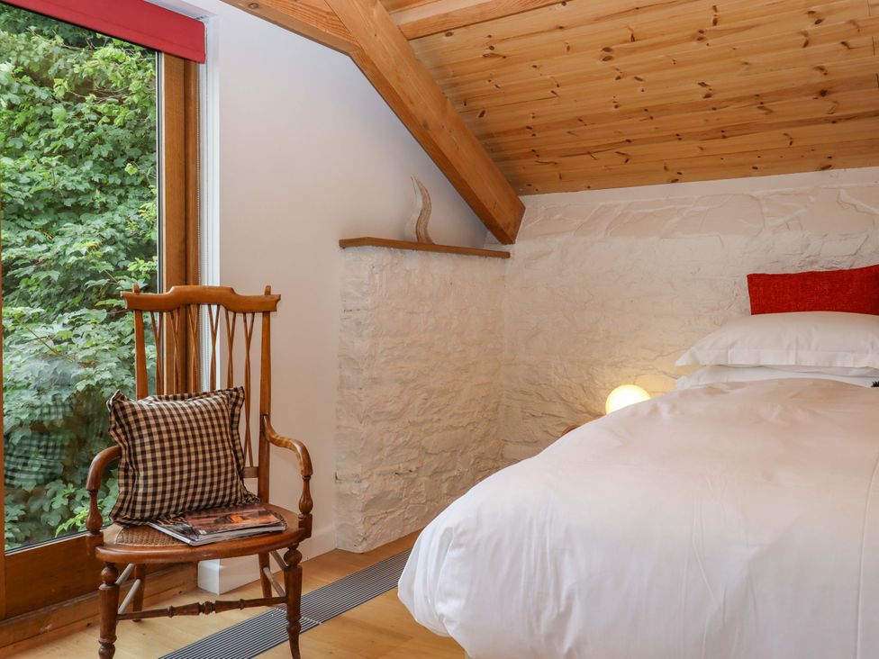 A bedroom with a bed and chair at Dolphin Cottage in Brixham