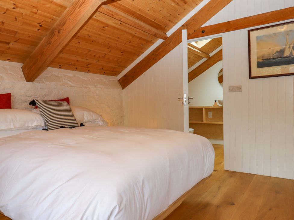 A bedroom with a bed and a shelf at Dolphin Cottage in Brixham