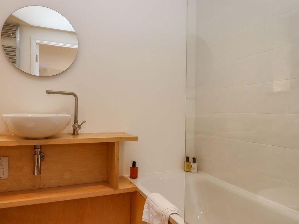 A bathroom with a washbasin and bathtub at Dolphin Cottage, Brixham