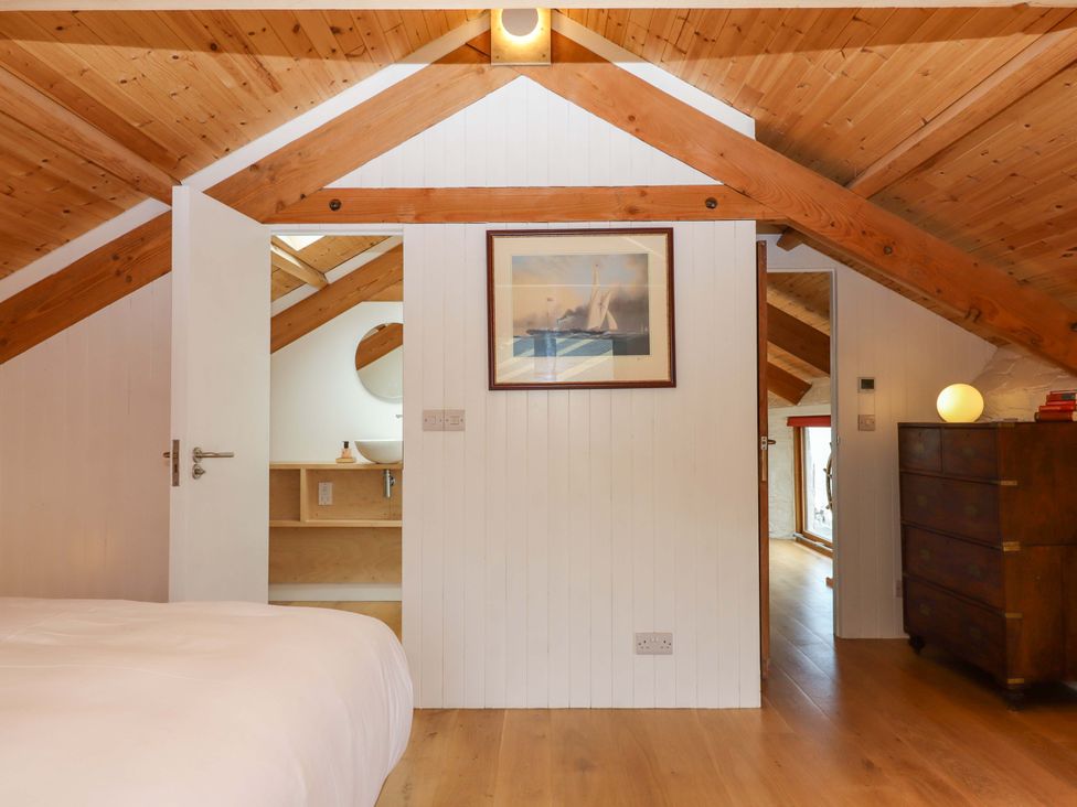 A bedroom with a bed and a door leading to another room at Dolphin Cottage in Brixham