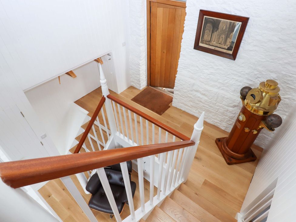 A staircase with a chair and decorative object at Dolphin Cottage in Brixham
