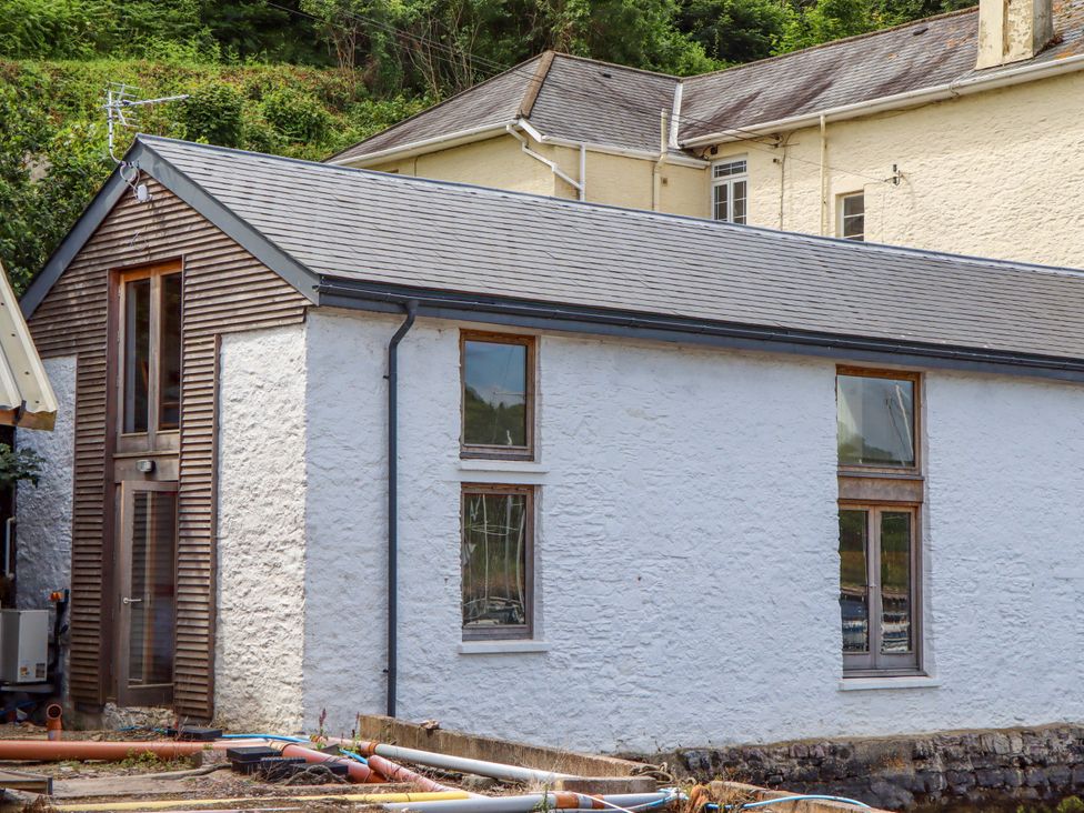 A building with a white exterior and wooden accents at Dolphin Cottage in Brixham