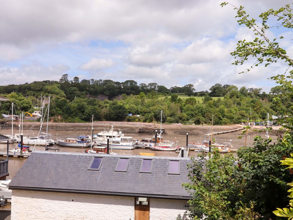 A view of boats on water with trees and a building roof at Dolphin Cottage in Brixham