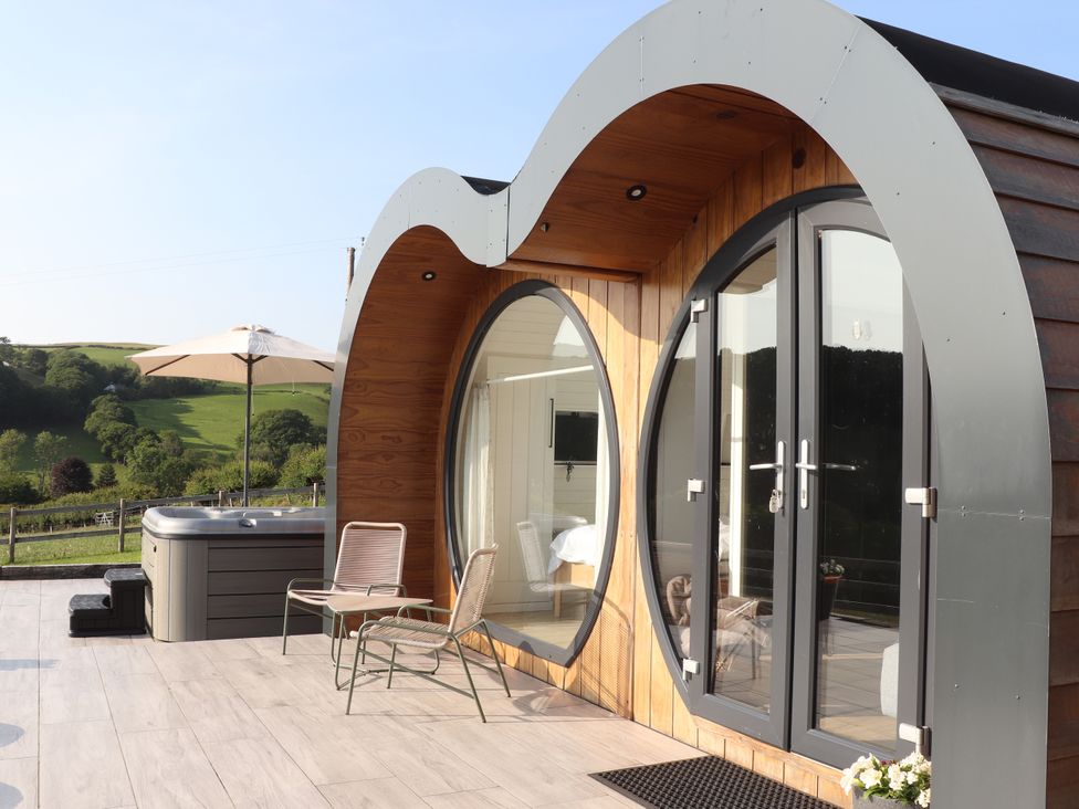 An outdoor area featuring a hot tub and seating at Ceunant, Llanfihangel-y-Creuddyn near Aberystwyth