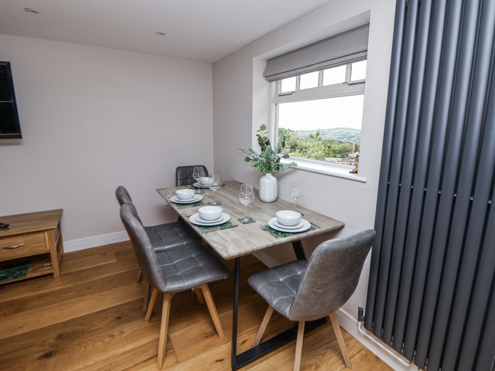 A dining room with a table set for four at Fern Cottage in Biddulph