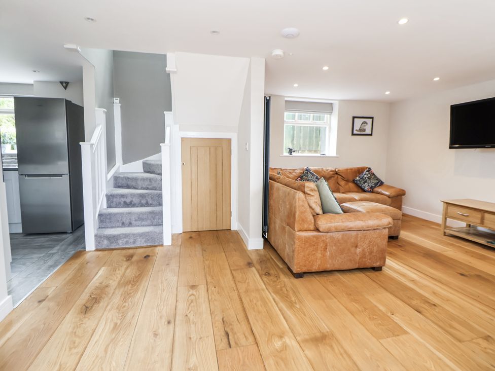 A living room with a sofa and television at Fern Cottage in Biddulph