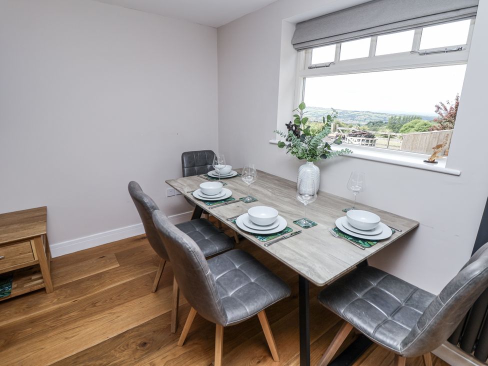 A dining room with a table set for four at Fern Cottage in Biddulph