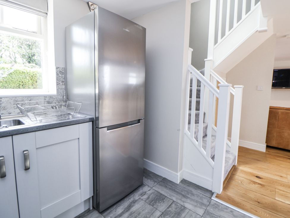 A kitchen with a refrigerator and sink at Fern Cottage in Biddulph