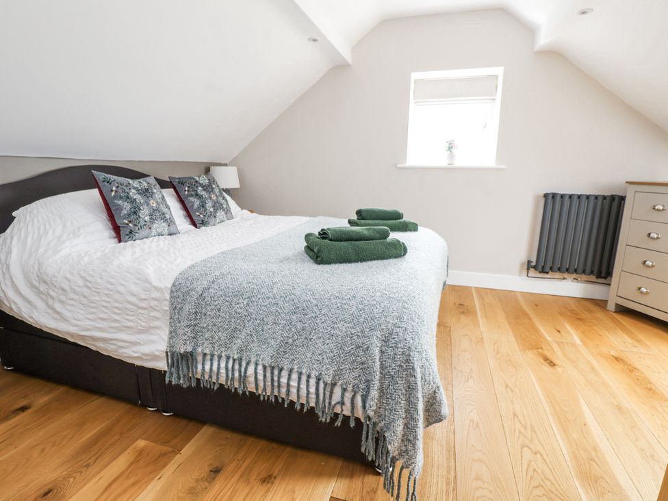A bedroom with a bed and pillows at Fern Cottage in Biddulph