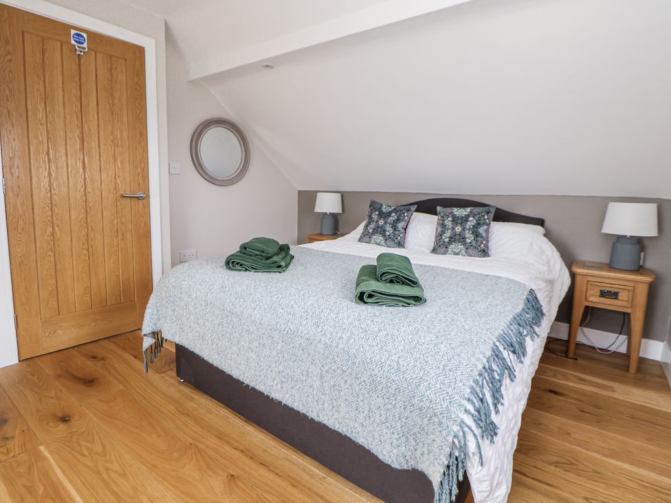 A bedroom with a bed and towels at Fern Cottage in Biddulph