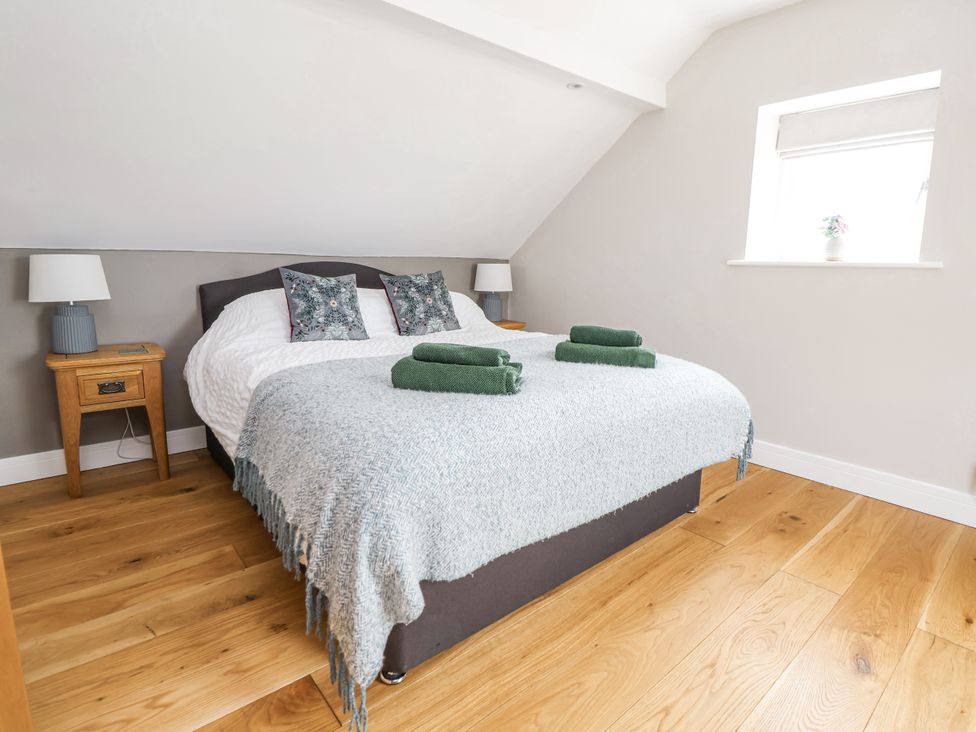 A bedroom with a bed and towels on the bed at Fern Cottage in Biddulph