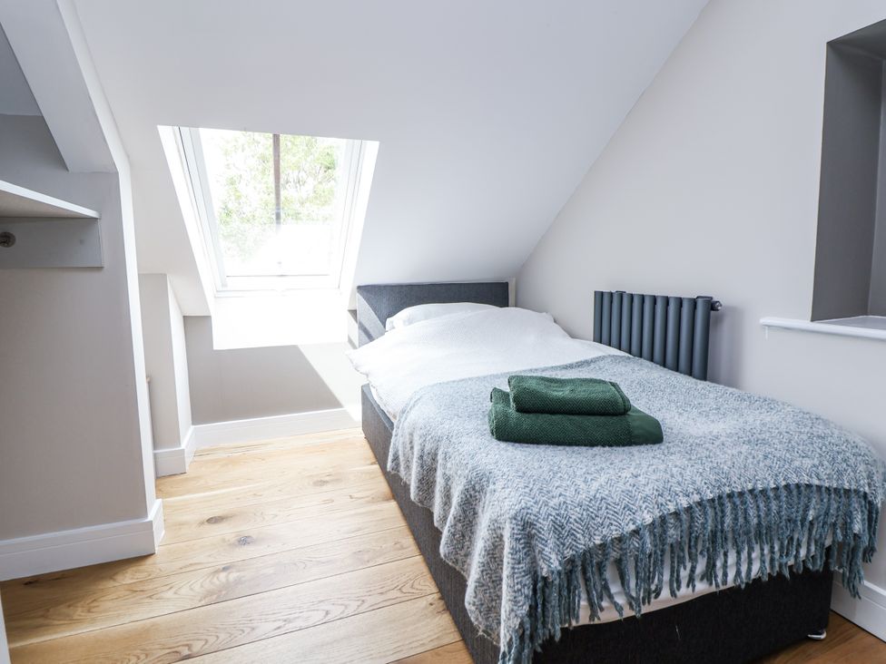 A bedroom with a bed and a window at Fern Cottage in Biddulph