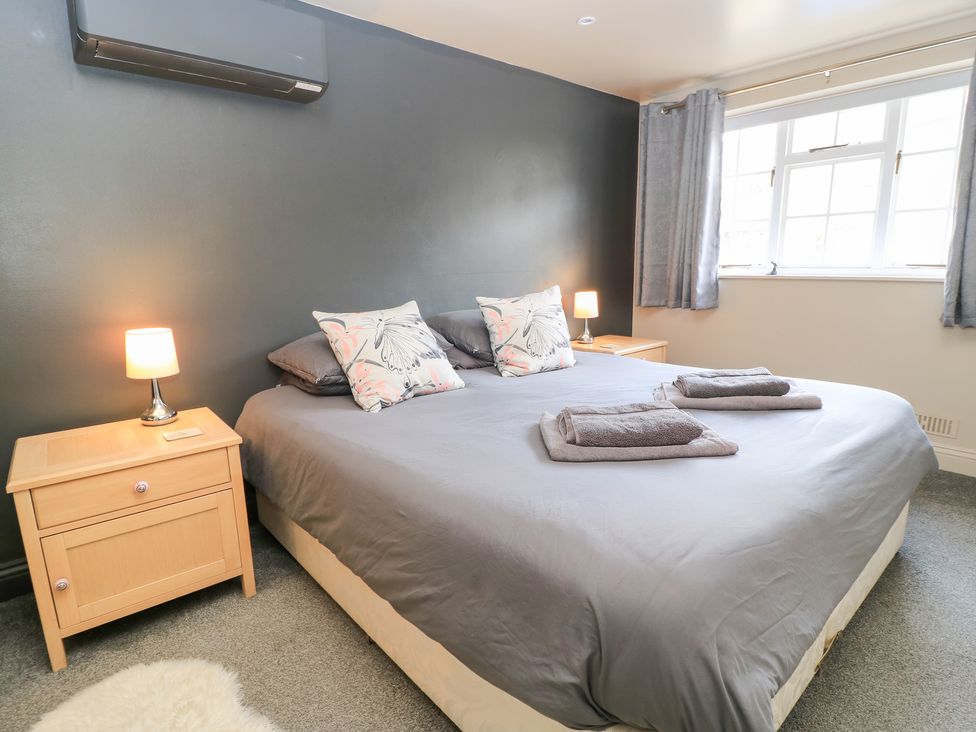 A bedroom with a bed and bedside tables at Well Cottage Nr Malmesbury