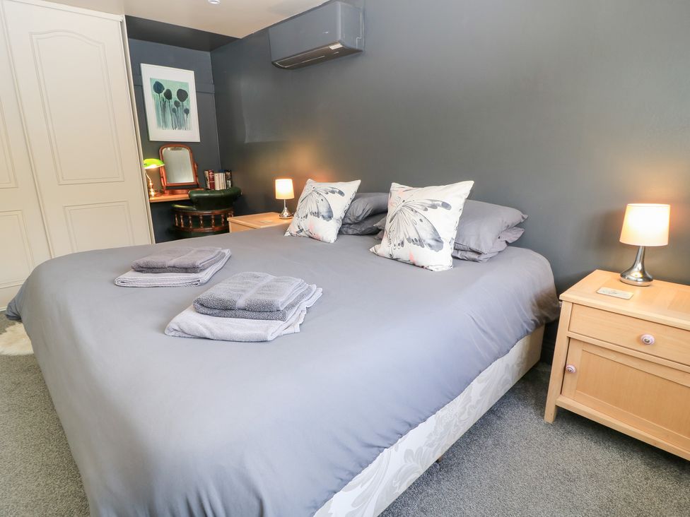 A bedroom with a double bed and bedside table at Well Cottage Nr Malmesbury