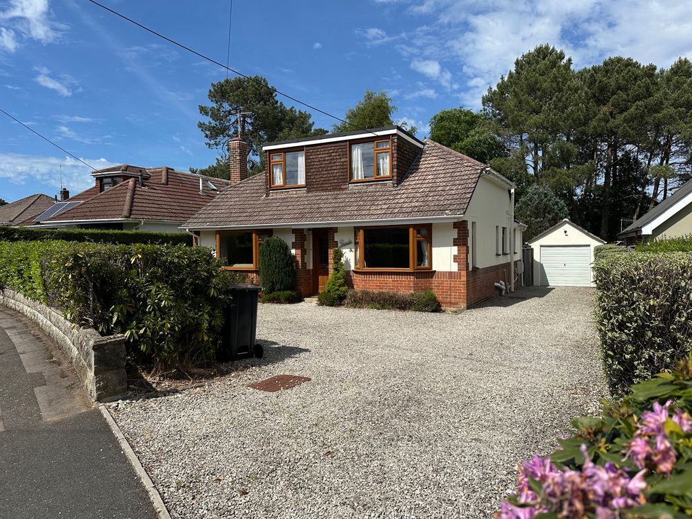 A house with a driveway and garage at Pineside, Sandford, Dorset
