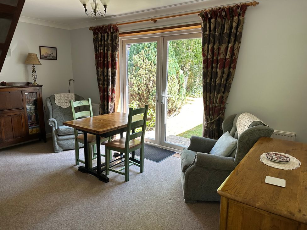 A dining room with a table and chairs at Pineside in Sandford, Dorset