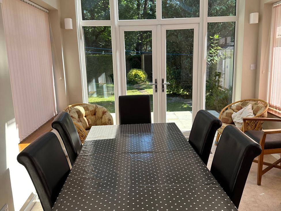 A dining room with a table and chairs at Pineside Sandford, Dorset