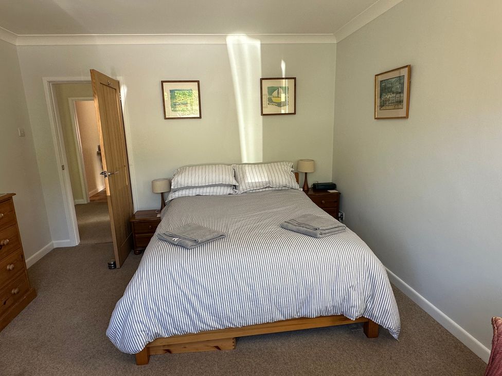 A bedroom with a bed and side table at Pineside Sandford, Dorset
