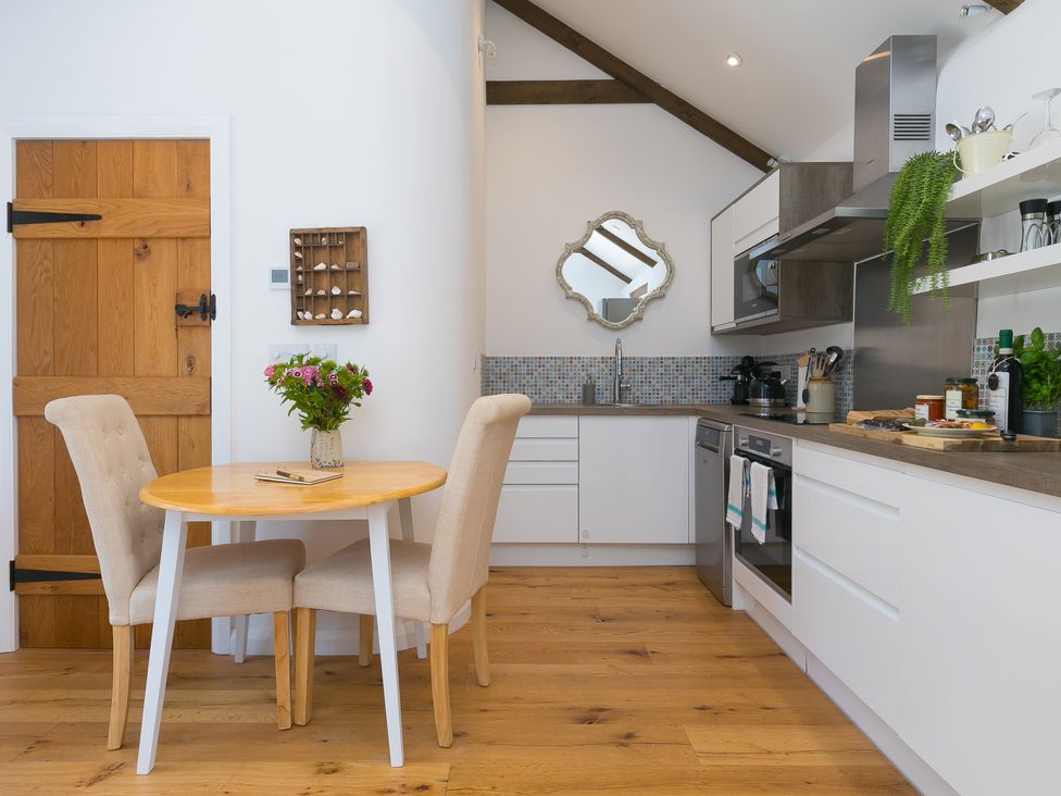 A kitchen with a table and chairs at Carines Barns - Tre in Cubert