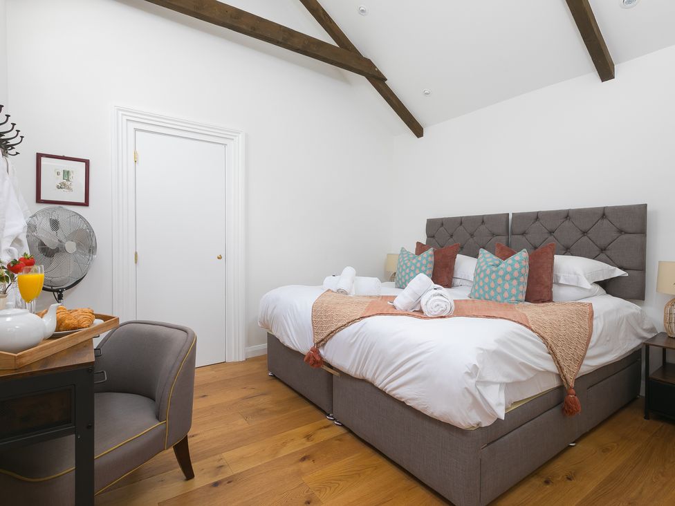 A bedroom with two beds and chairs at Carines Barns - Tre in Cubert
