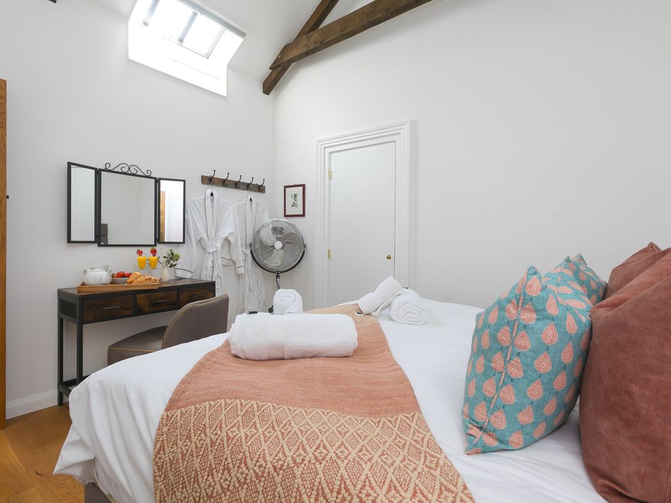 A bedroom with a bed and vanity table at Carines Barns - Tre, Cubert