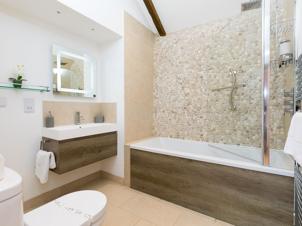 A bathroom with a shower, sink, and bathtub at Carines Barns - Tre, Cubert