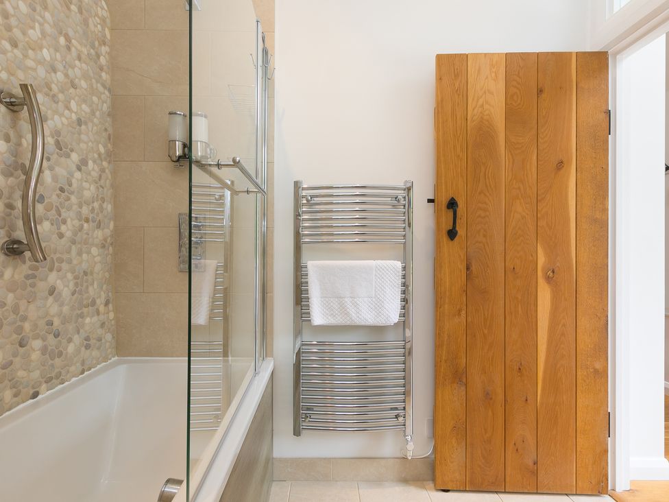 A bathroom with a tub and towel rack at Carines Barns - Tre in Cubert