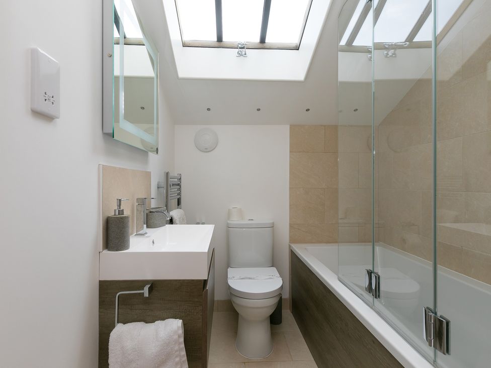 A bathroom with a sink, toilet, and bathtub at Carines Barns - Cubert