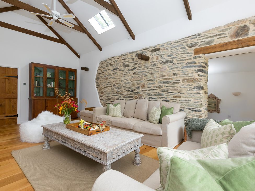 A living room with a sofa and coffee table at Carines Barns - Wesley Barn, Cubert