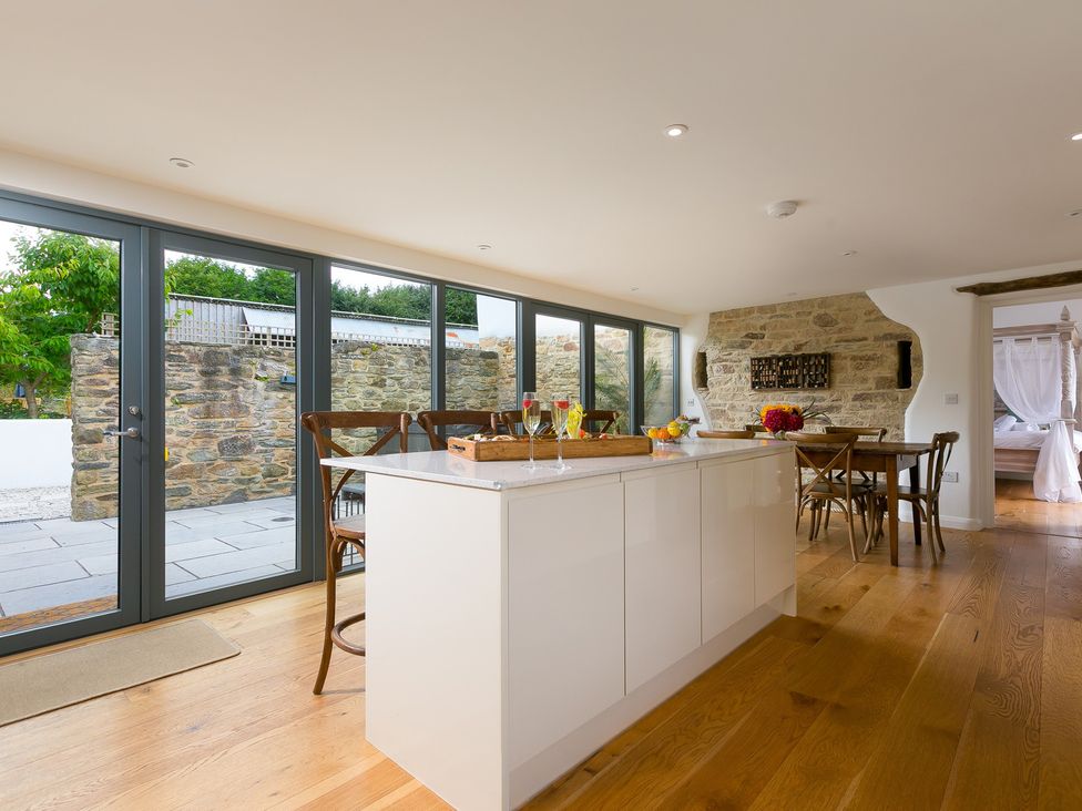 A kitchen with a large island and dining area at Carines Barns - Wesley Barn in Cubert