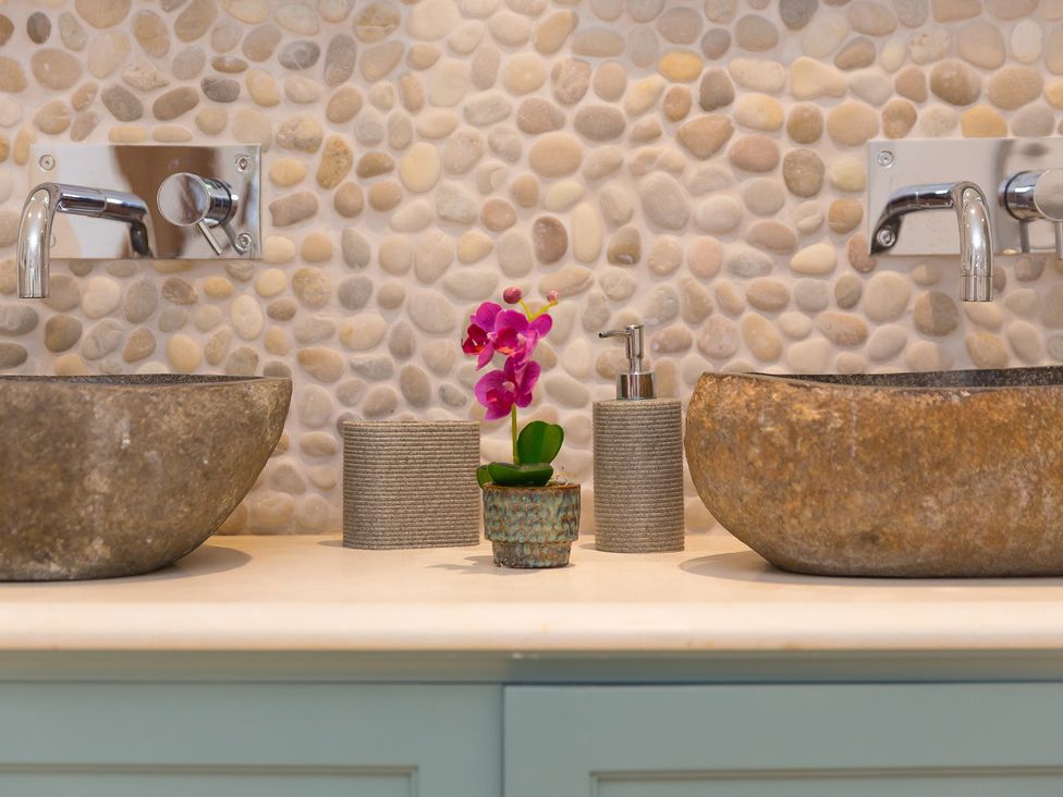 A bathroom with stone sinks and a flower pot at Carines Barns - Wesley Barn, Cubert