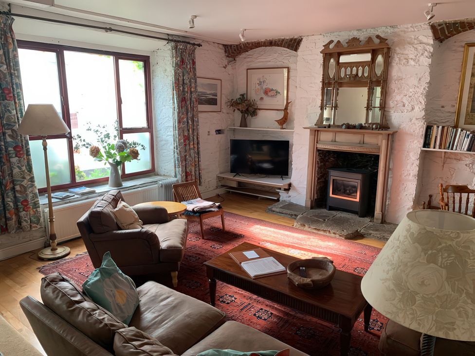 A living room with a sofa, armchairs and a television at Lower Mill in Dittisham