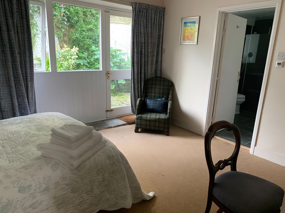 A bedroom with a bed and towels at Lower Mill in Dittisham