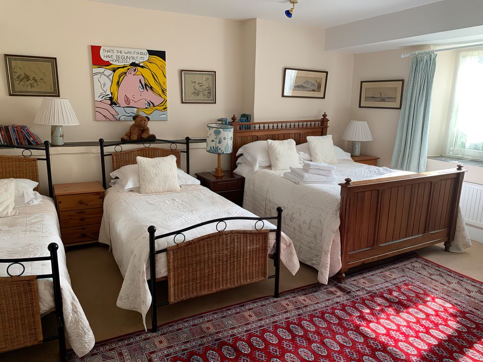 A bedroom with three beds and a painting at Lower Mill in Dittisham