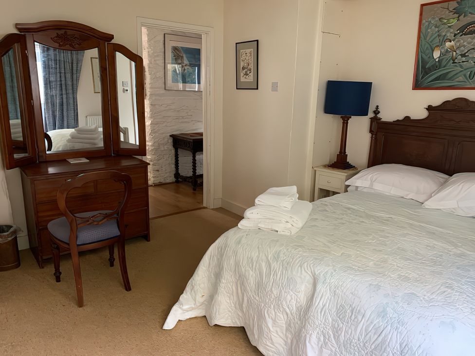 A bedroom with a bed and dressing table at Lower Mill in Dittisham