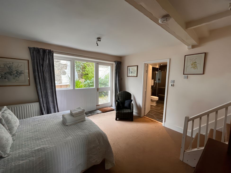 A bedroom with a bed and an adjoining bathroom at Lower Mill in Dittisham