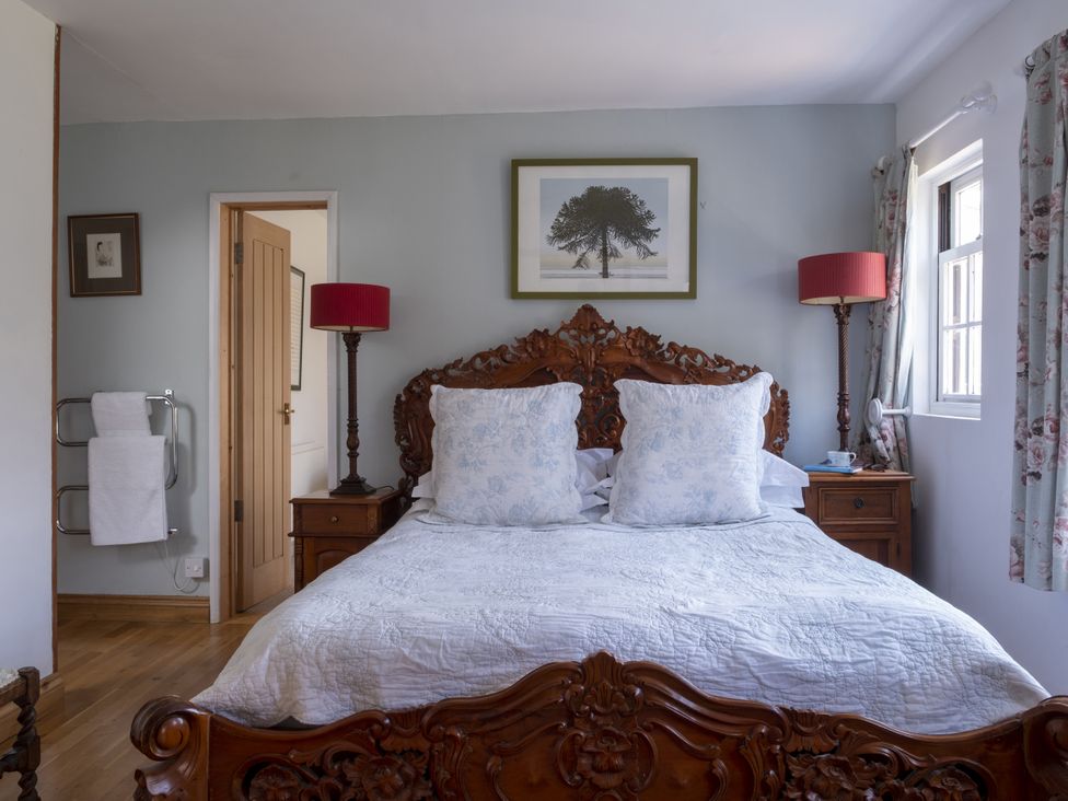 A bedroom with a bed, bedside table and lamp at Wisteria Suite in Dittisham