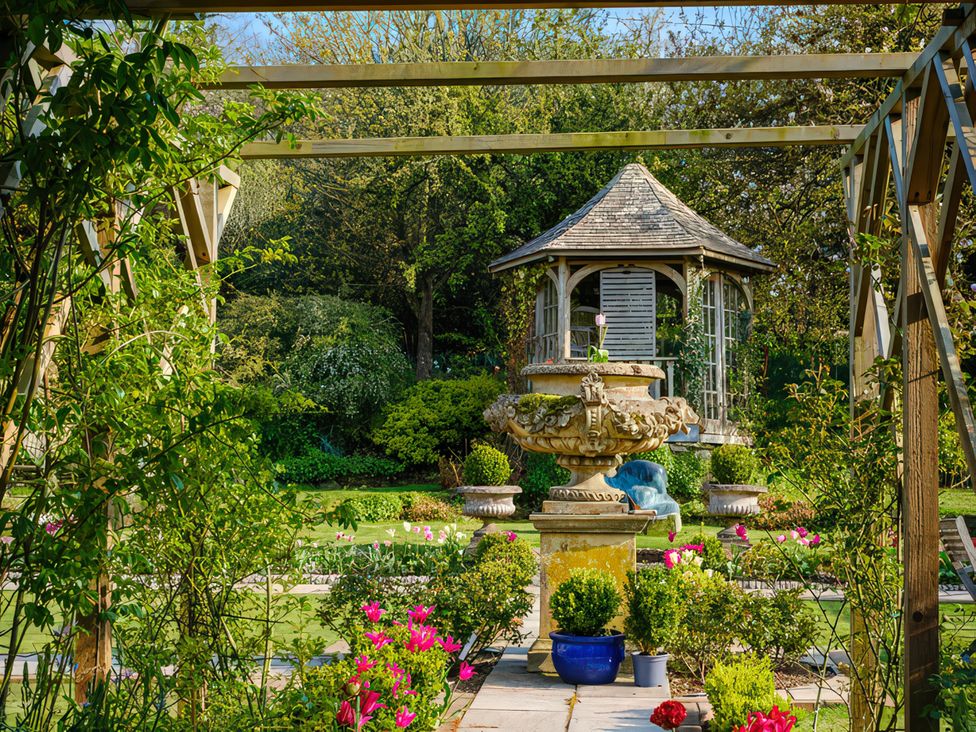 A garden with a fountain and gazebo at Barberry Brook in Dittisham