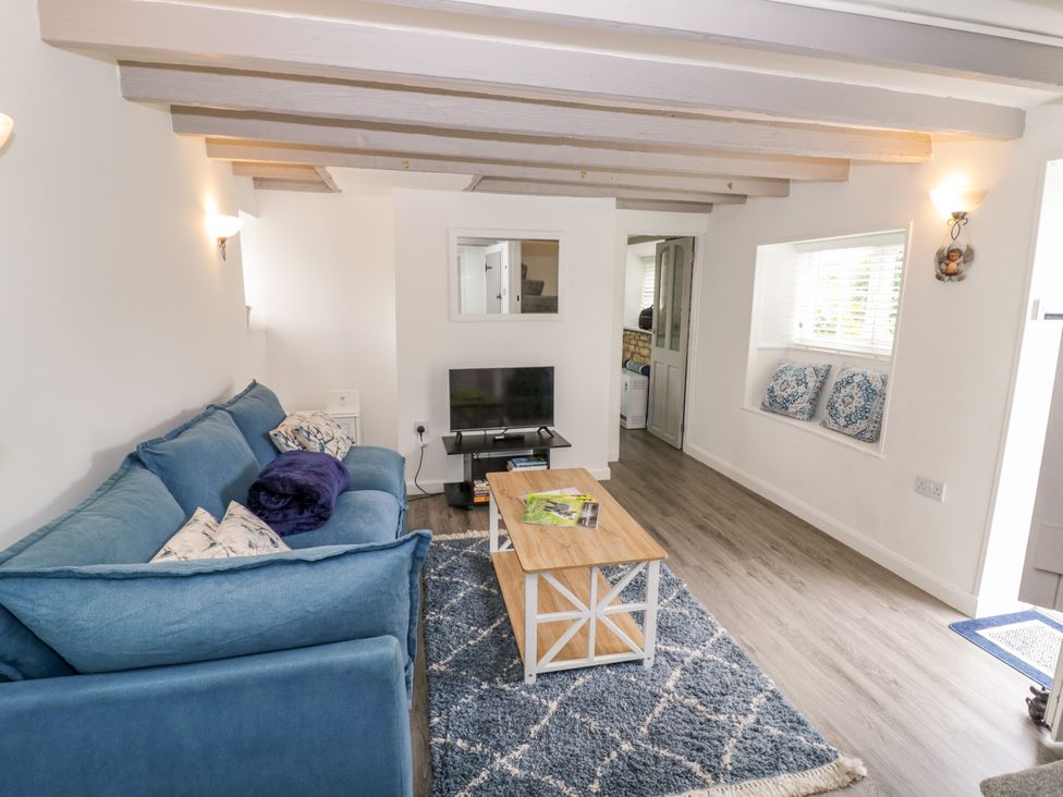 A living room with a sofa and coffee table at The Cottage in Ettington