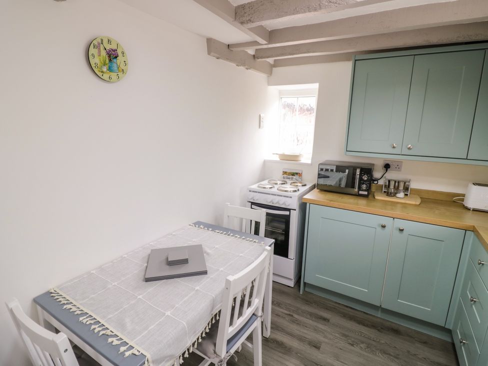 A kitchen with a dining table and stove at The Cottage in Ettington