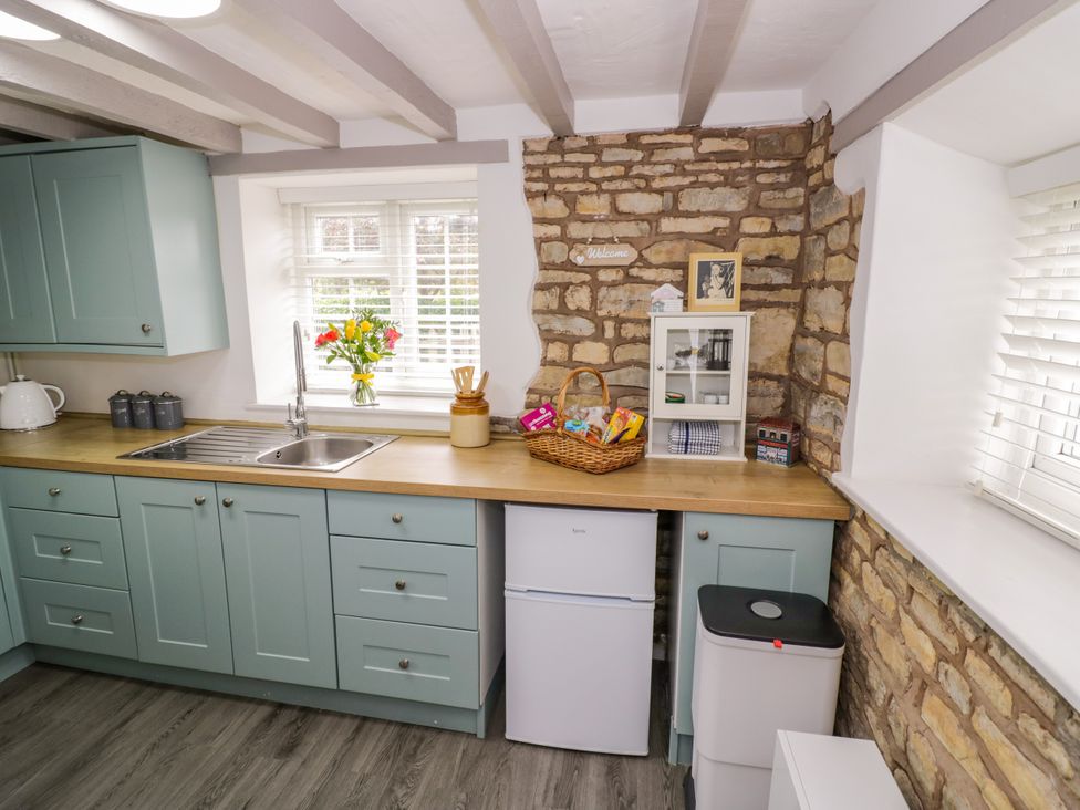 A kitchen with a sink and fridge at The Cottage in Ettington