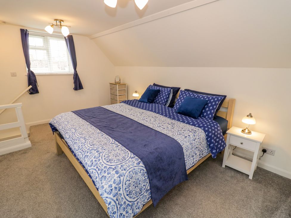 A bedroom with a bed and nightstand at The Cottage in Ettington
