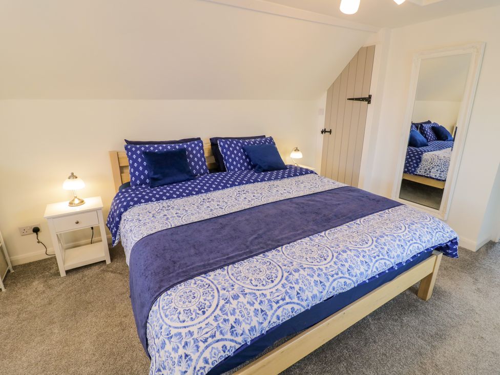 A bedroom with a bed and nightstand at The Cottage in Ettington